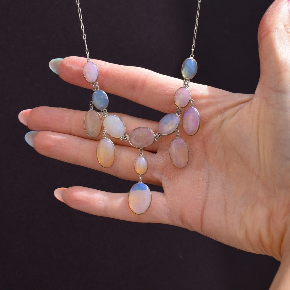 An Edwardian silver festoon necklace featuring graduated oval cabochon opals arranged in hanging fringe drops. View XI