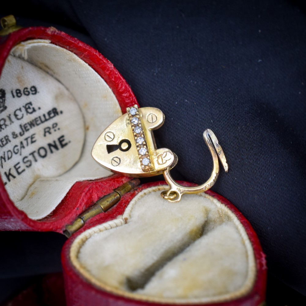 An antique 9ct yellow gold heart-shaped padlock charm set with a row of small round diamonds across the centre bar and featuring an engraved keyhole design. View II