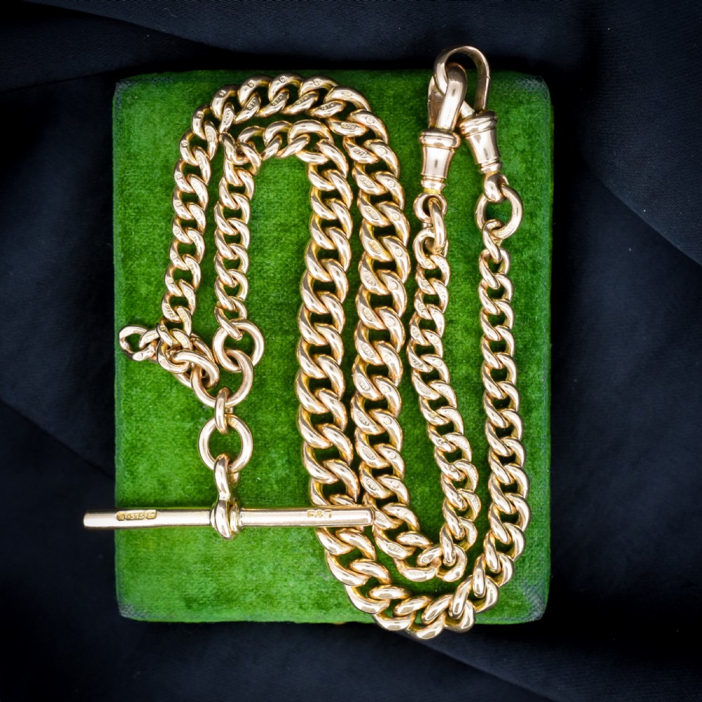An antique 9ct yellow gold curb link Albert watch chain featuring a central T-bar drop and swivel dog clip fasteners.