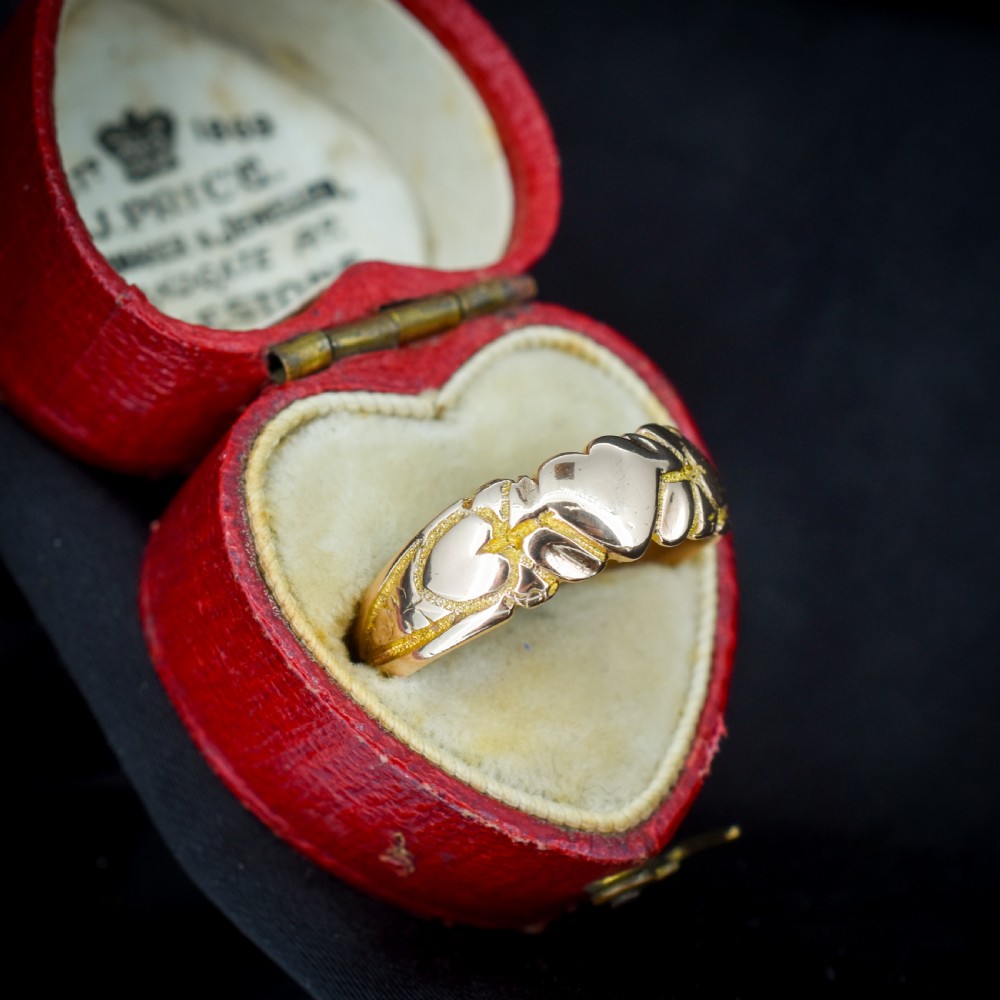 An antique Victorian 9ct yellow gold band ring featuring polished heart motifs set against textured background detailing. View III
