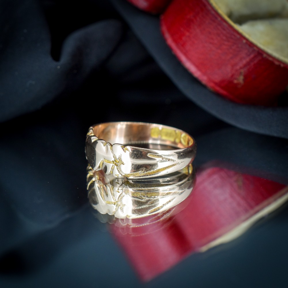 An antique Victorian 9ct yellow gold band ring featuring polished heart motifs set against textured background detailing. View VII
