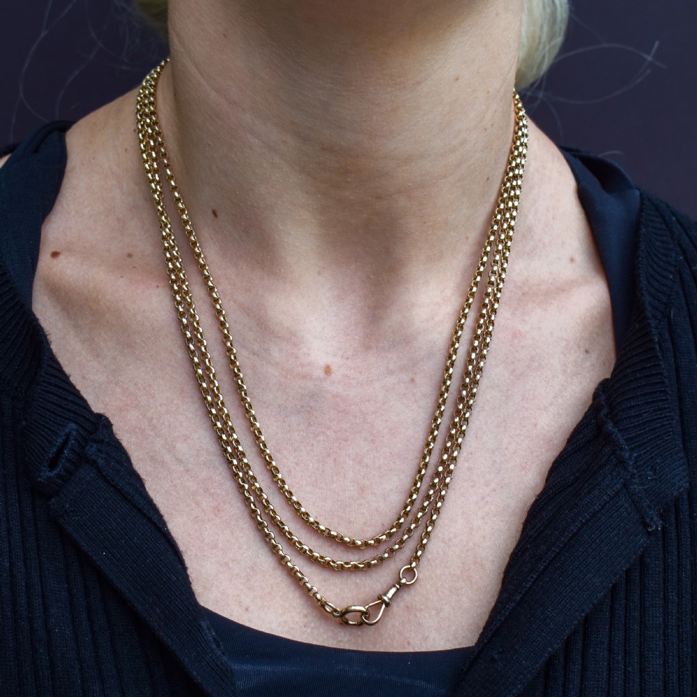 A long 9ct yellow gold Victorian guard chain featuring circular belcher links layered in four loops, secured with a swivel clasp. View IX