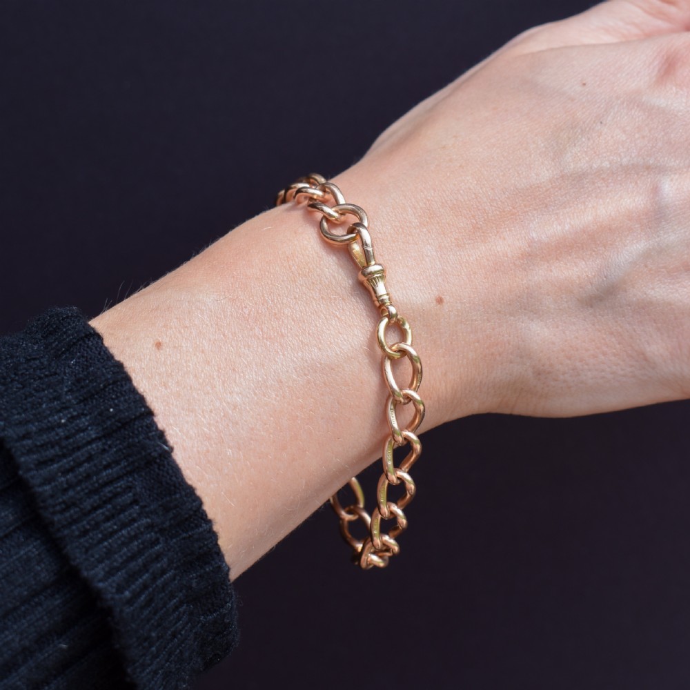 An antique 15ct warm gold oval curb link bracelet featuring stamped links and a dog clip swivel clasp. View IX