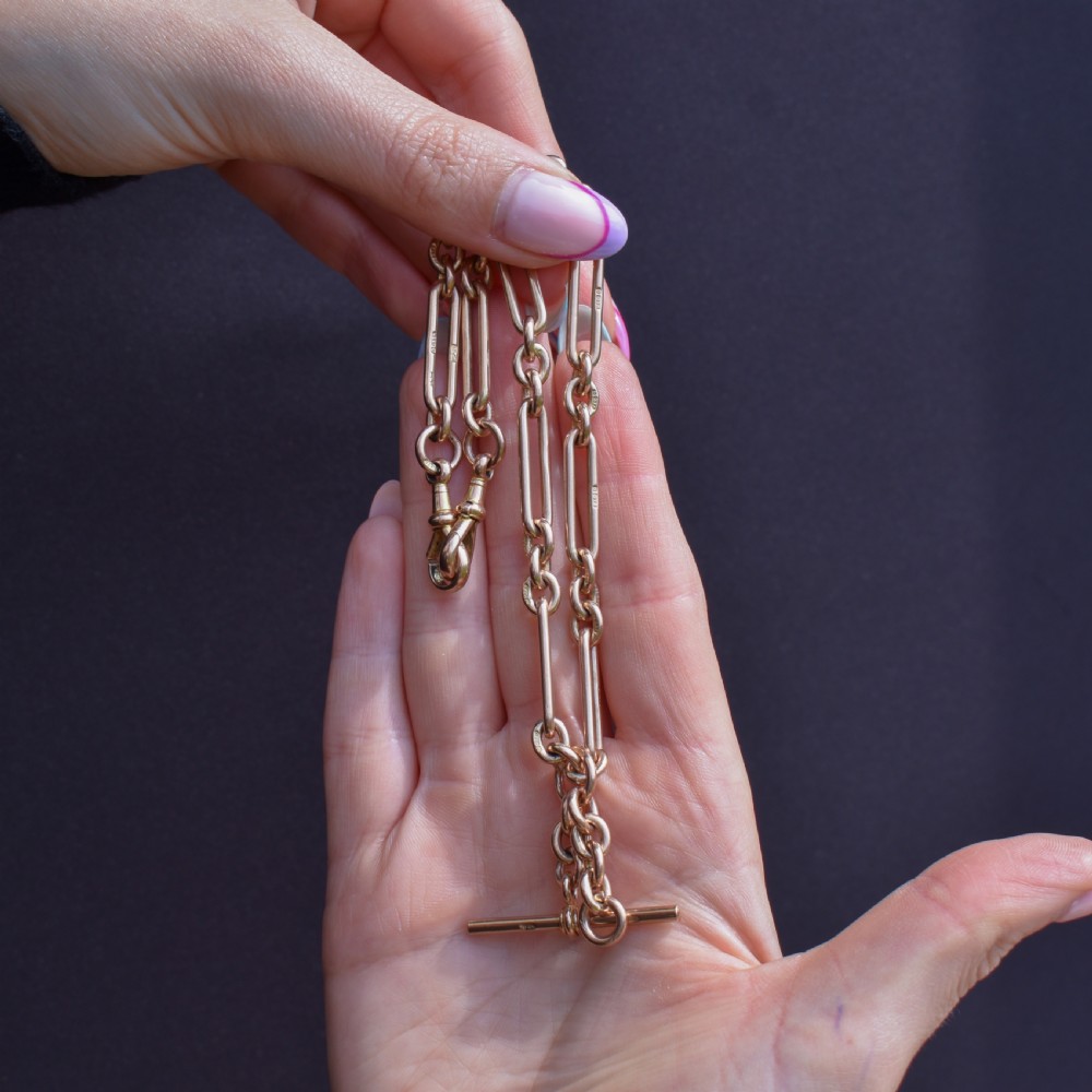 An antique 9ct yellow gold Albert watch chain featuring elongated trombone links, connector rings, a T-bar, and a swivel clasp. View II