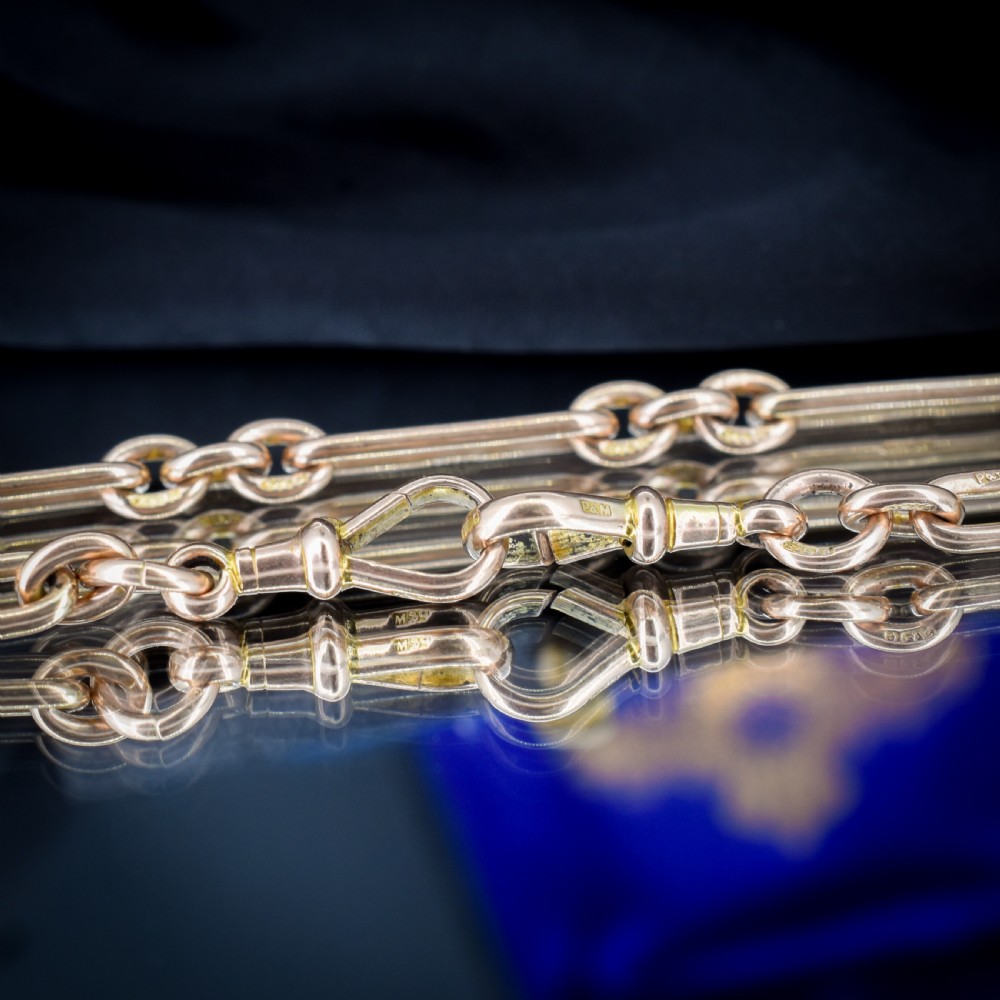 An antique 9ct yellow gold Albert watch chain featuring elongated trombone links, connector rings, a T-bar, and a swivel clasp. View XI