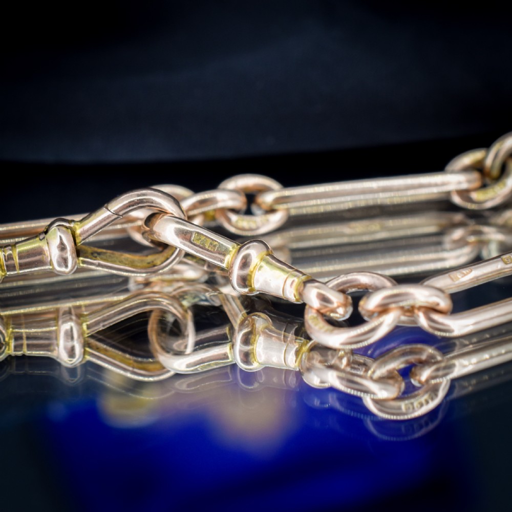An antique 9ct yellow gold Albert watch chain featuring elongated trombone links, connector rings, a T-bar, and a swivel clasp. View XII