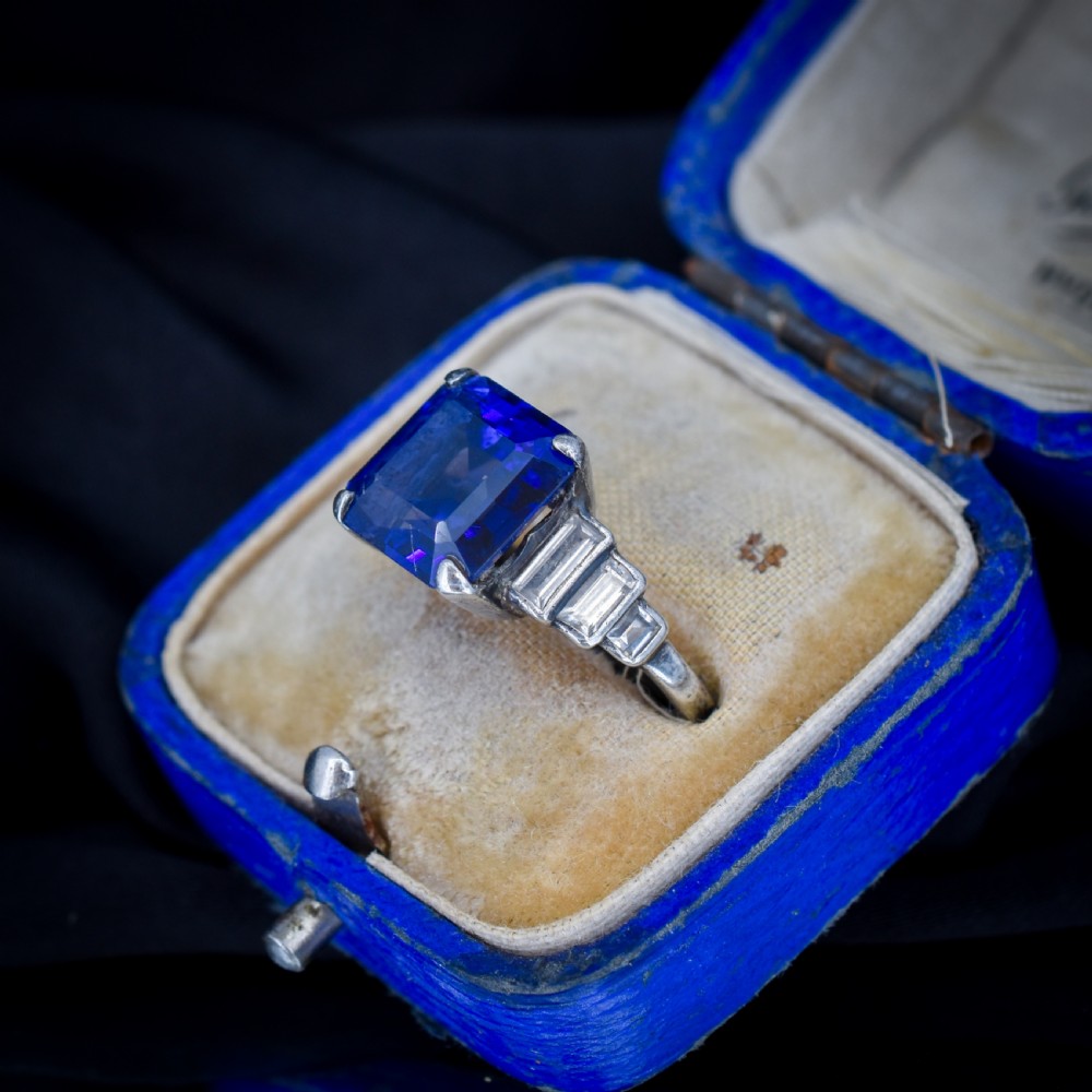 An Art Deco sterling silver cocktail ring set with a large square-cut blue gemstone and stepped baguette-cut side stones. View III