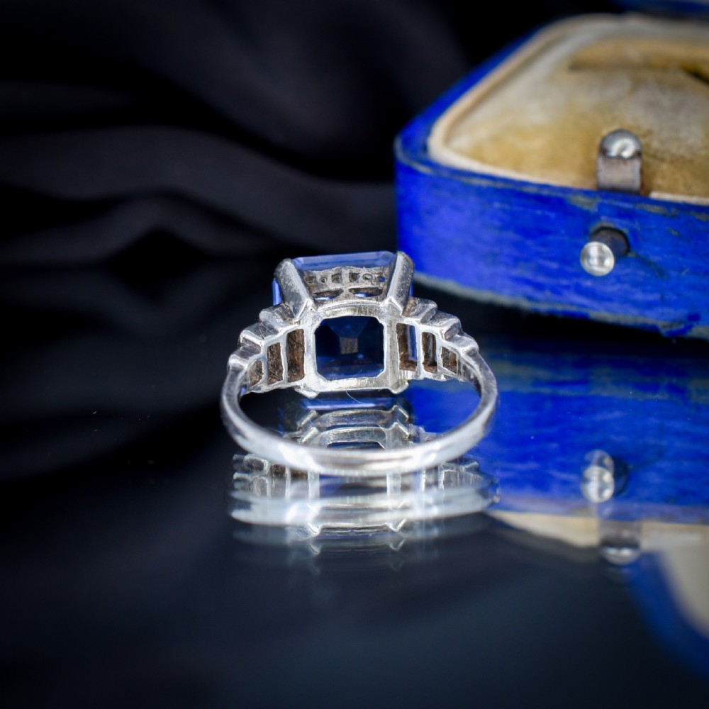 An Art Deco sterling silver cocktail ring set with a large square-cut blue gemstone and stepped baguette-cut side stones. View VI
