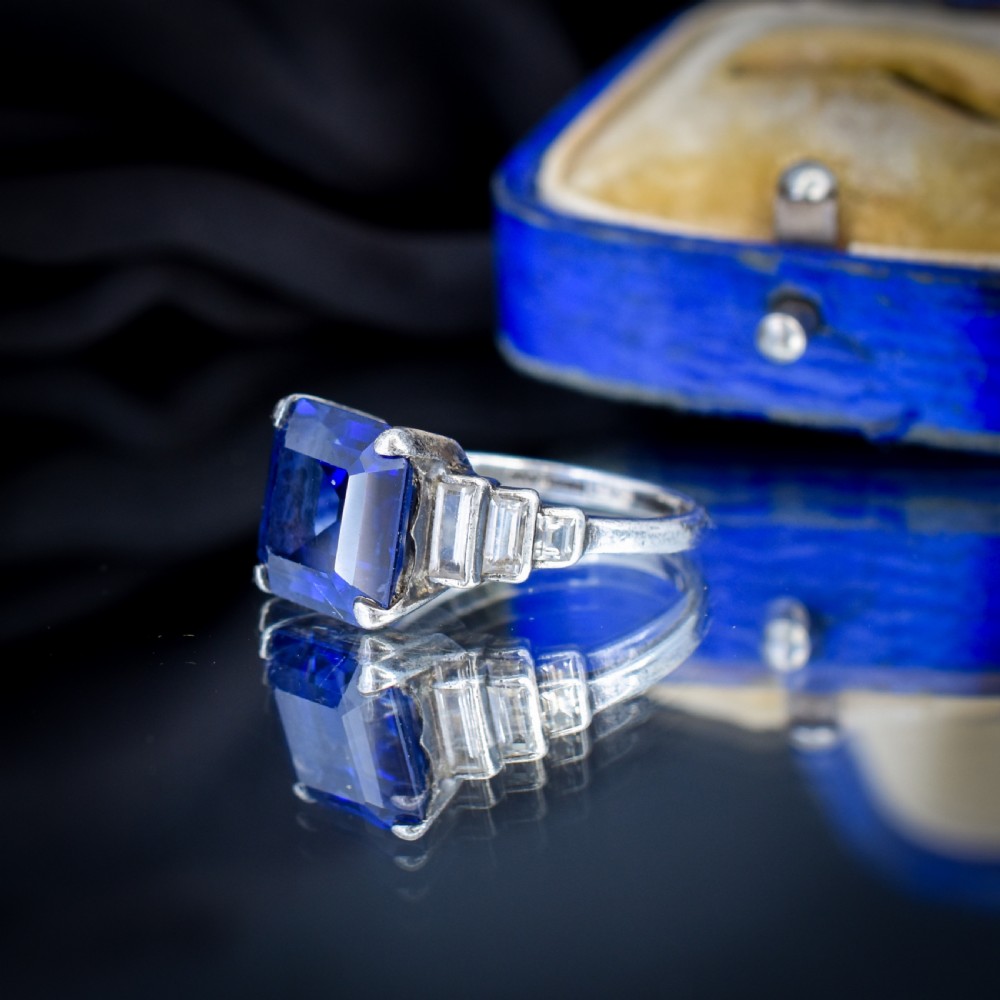 An Art Deco sterling silver cocktail ring set with a large square-cut blue gemstone and stepped baguette-cut side stones. View VII