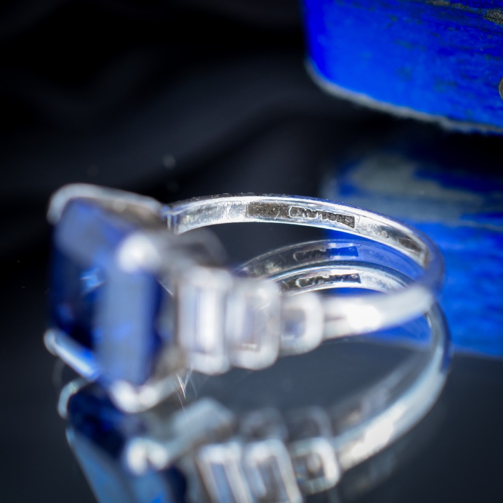 An Art Deco sterling silver cocktail ring set with a large square-cut blue gemstone and stepped baguette-cut side stones. View VIII