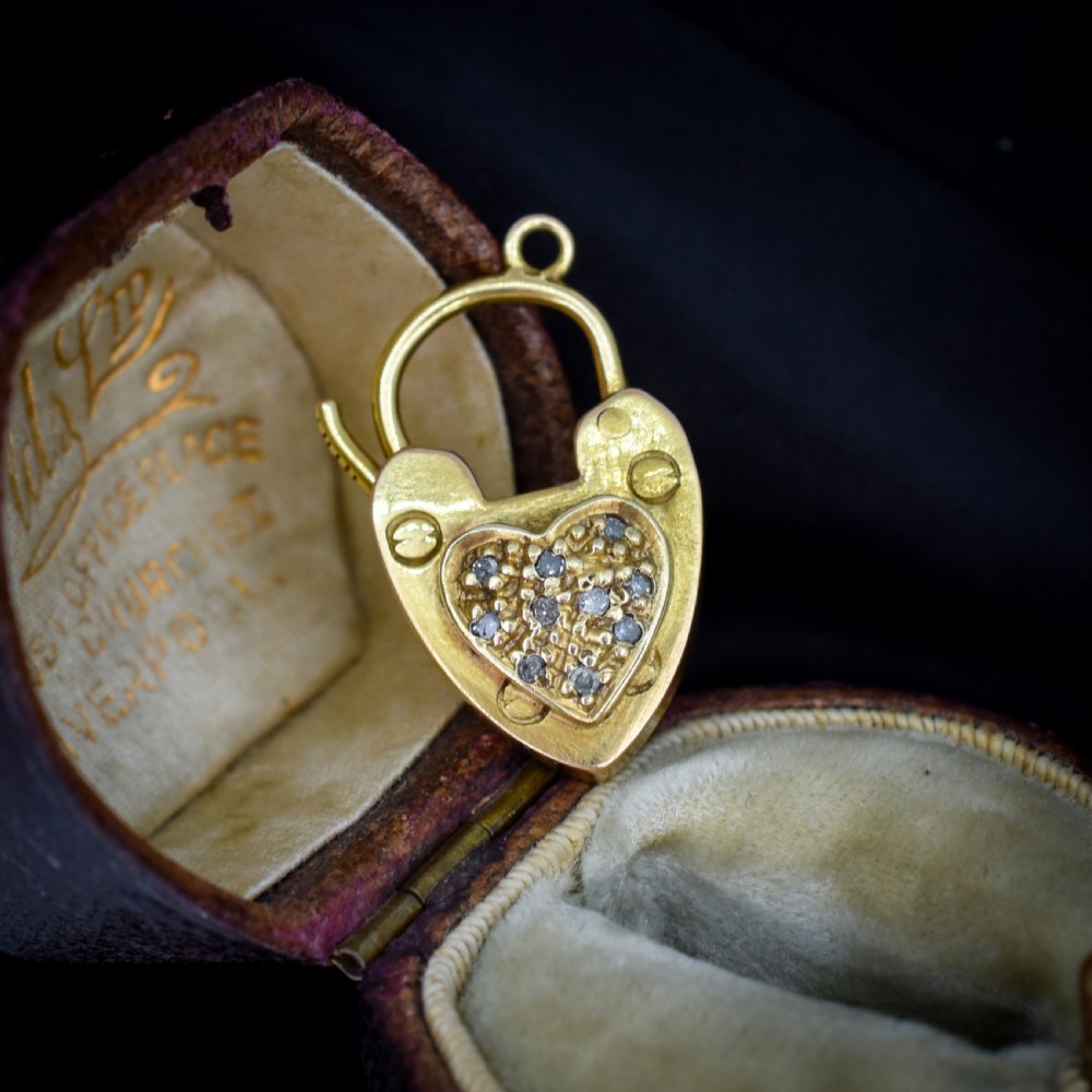 An Edwardian 9ct yellow gold heart-shaped padlock charm featuring a pave diamond centre and a hinged top arch. View II
