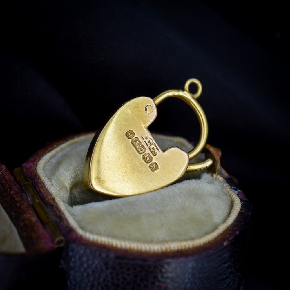 An Edwardian 9ct yellow gold heart-shaped padlock charm featuring a pave diamond centre and a hinged top arch. View III