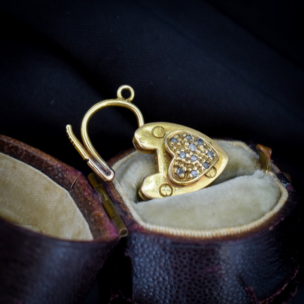 An Edwardian 9ct yellow gold heart-shaped padlock charm featuring a pave diamond centre and a hinged top arch. View IV