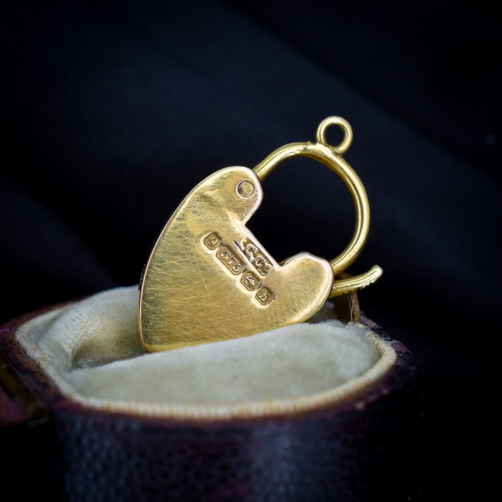 An Edwardian 9ct yellow gold heart-shaped padlock charm featuring a pave diamond centre and a hinged top arch. View V