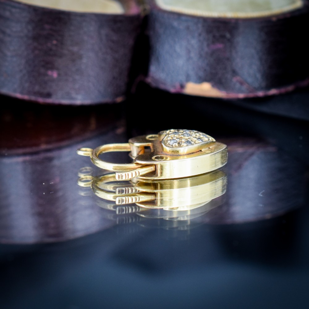 An Edwardian 9ct yellow gold heart-shaped padlock charm featuring a pave diamond centre and a hinged top arch. View VII