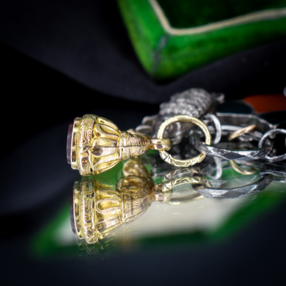 A cluster of antique silver and gold-gilt novelty charms, including pigs and a bugle, attached to a central metal split ring. View VI