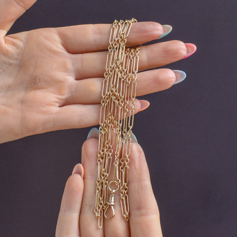 An antique long 9ct yellow gold paper link chain necklace layered around a black display bust with a swivel dog clip clasp. View IX