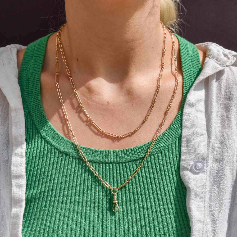 An antique long 9ct yellow gold paper link chain necklace layered around a black display bust with a swivel dog clip clasp. View X