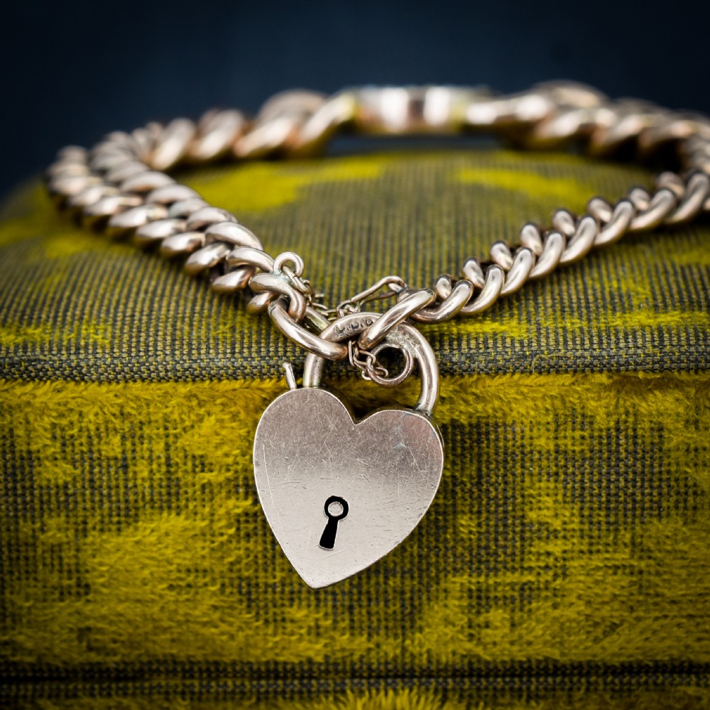 An antique 9ct rose gold curb chain bracelet featuring a heart padlock clasp and a central crescent moon and star motif set with seed pearls. View II