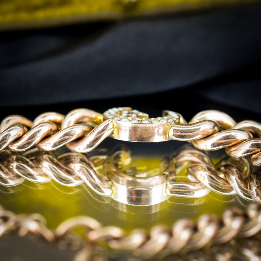 An antique 9ct rose gold curb chain bracelet featuring a heart padlock clasp and a central crescent moon and star motif set with seed pearls. View VI