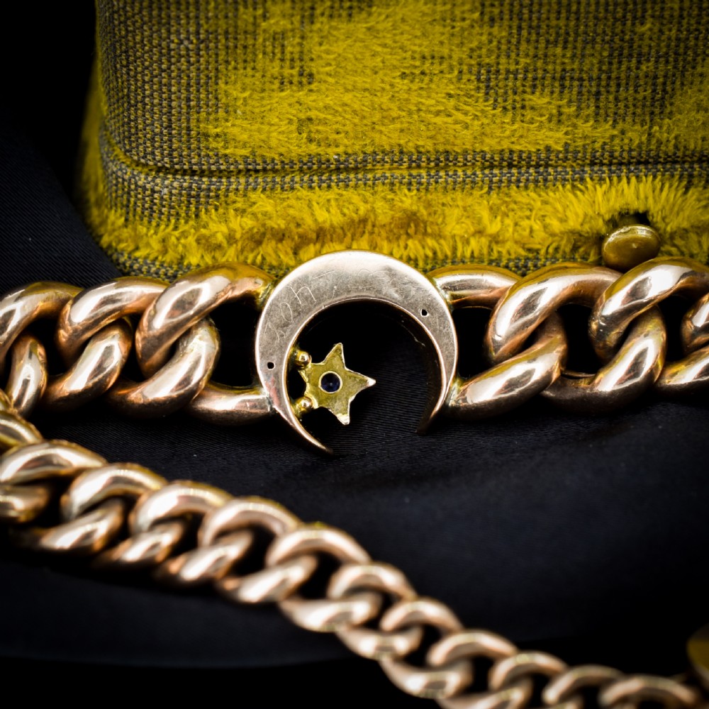 An antique 9ct rose gold curb chain bracelet featuring a heart padlock clasp and a central crescent moon and star motif set with seed pearls. View VII