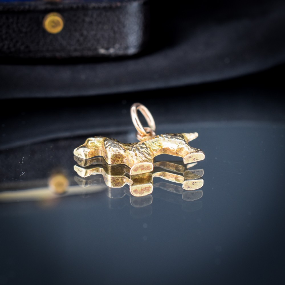 A small 9ct yellow gold charm cast in the detailed shape of a standing spaniel dog with a textured coat and an attached jump ring. View VIII