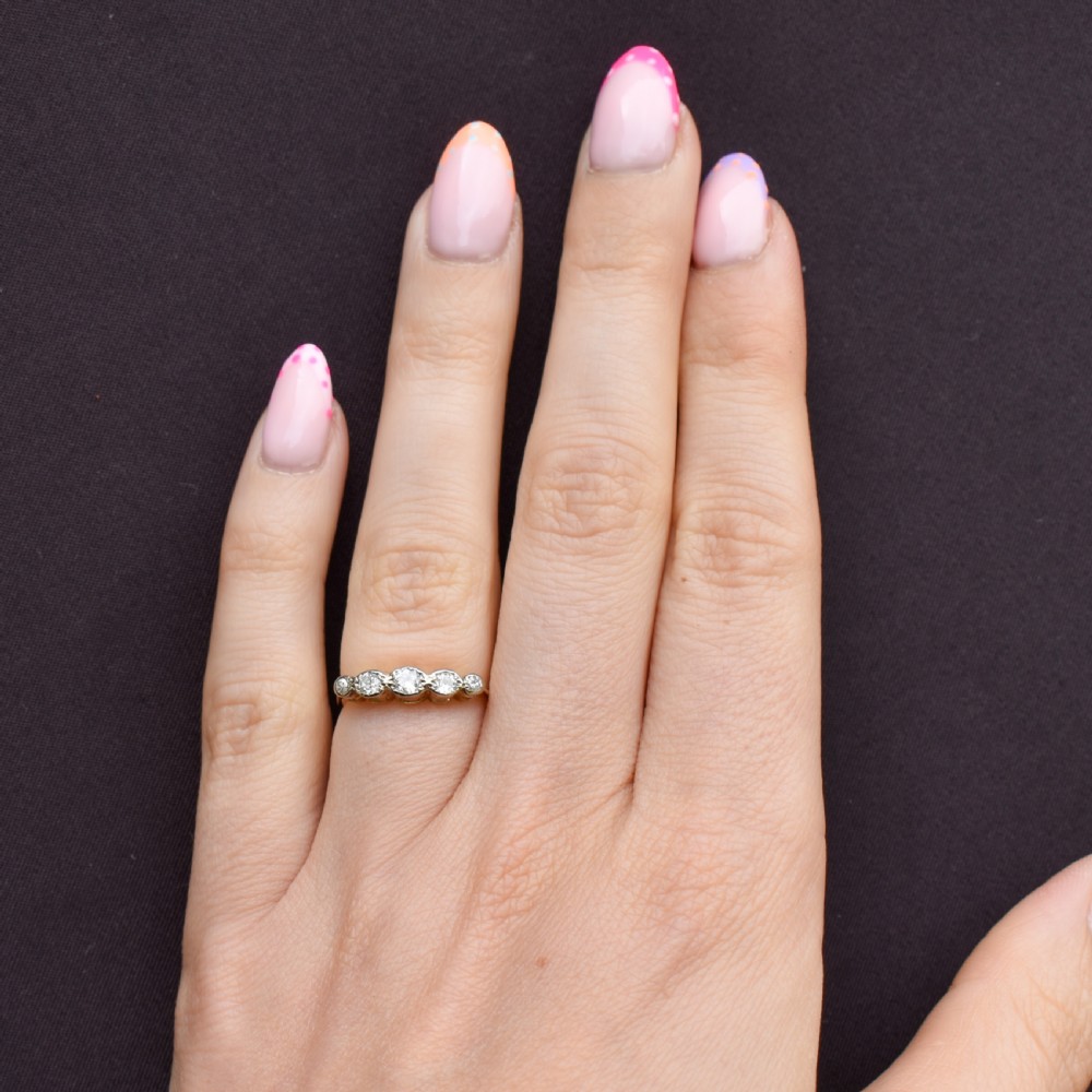 An antique 18ct yellow gold ring set with five round diamonds arranged horizontally in a row across the band. View III