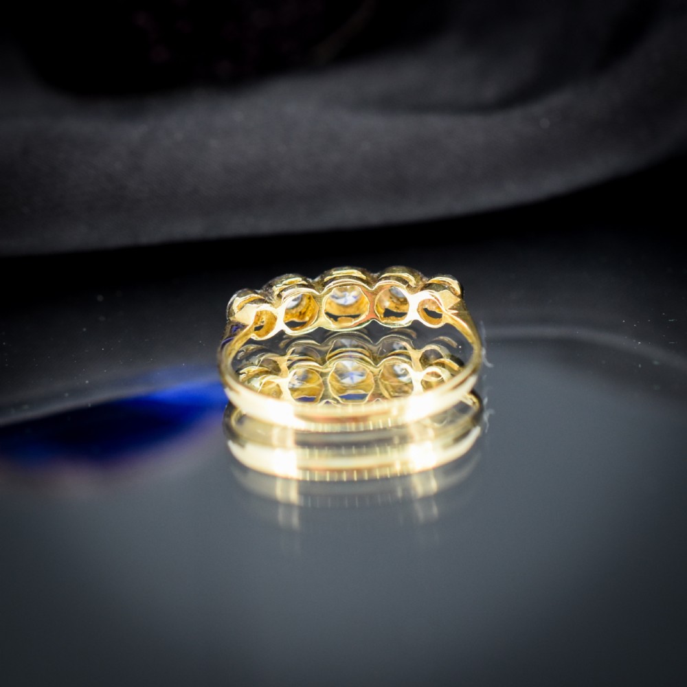 An antique 18ct yellow gold ring set with five round diamonds arranged horizontally in a row across the band. View VIII