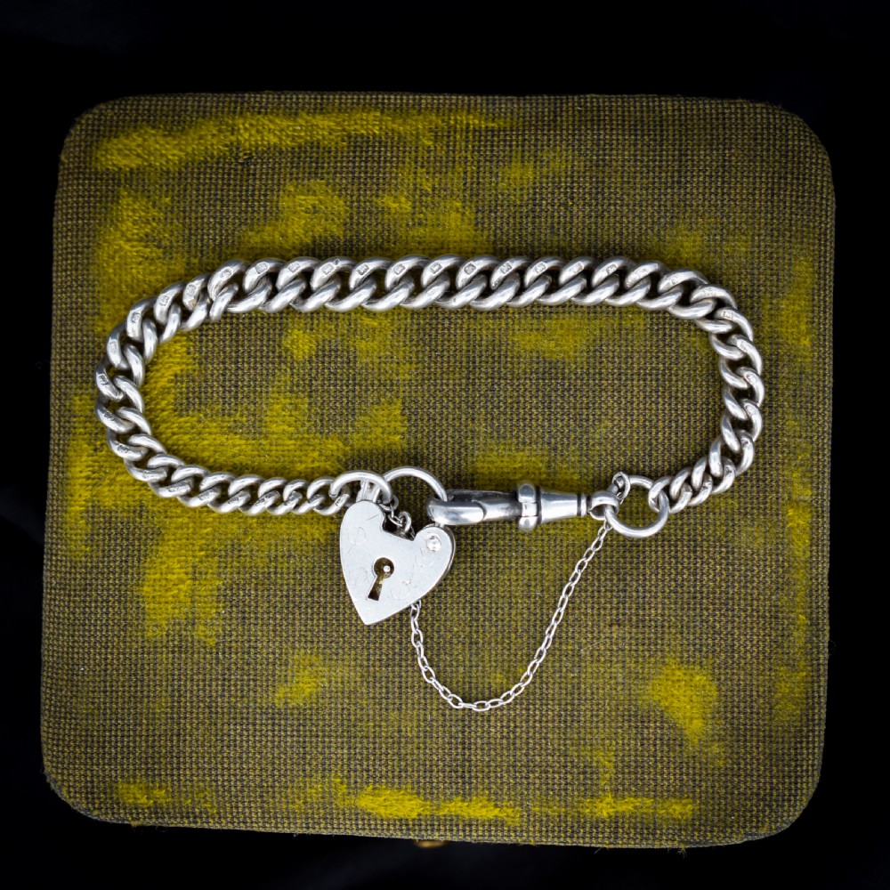 An antique sterling silver graduated curb link bracelet featuring a heart-shaped padlock clasp, safety chain, and a swivel dog clip attachment. View II