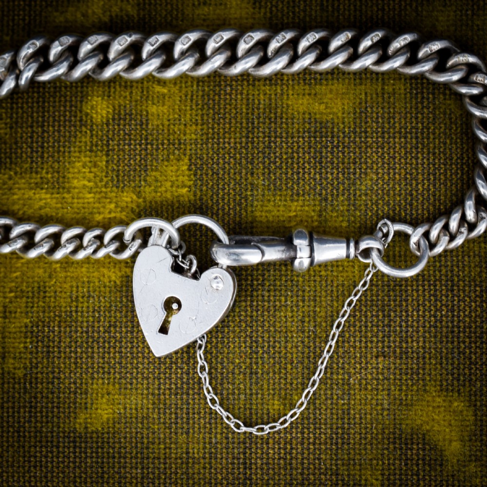 An antique sterling silver graduated curb link bracelet featuring a heart-shaped padlock clasp, safety chain, and a swivel dog clip attachment. View III