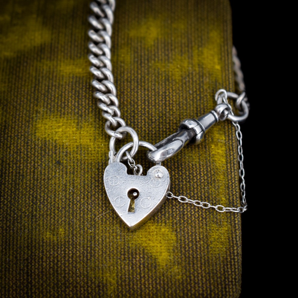 An antique sterling silver graduated curb link bracelet featuring a heart-shaped padlock clasp, safety chain, and a swivel dog clip attachment. View VI