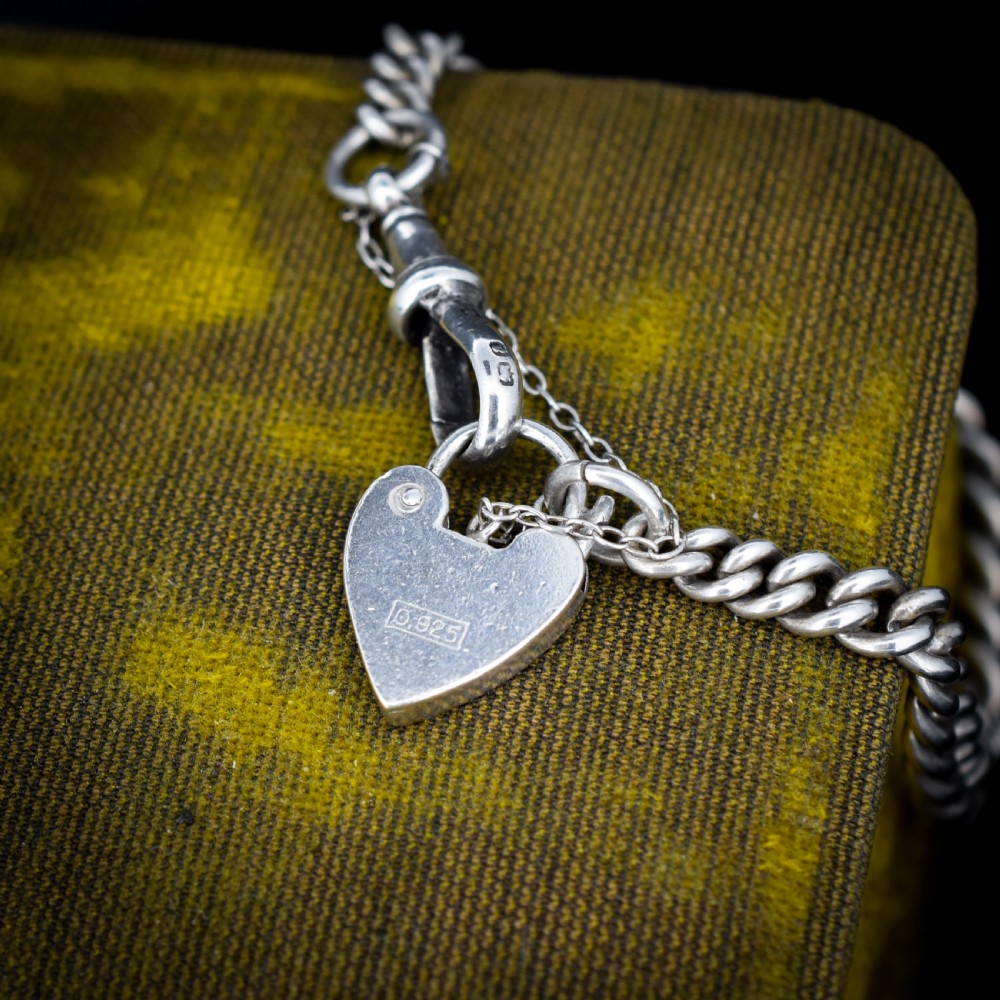 An antique sterling silver graduated curb link bracelet featuring a heart-shaped padlock clasp, safety chain, and a swivel dog clip attachment. View VII