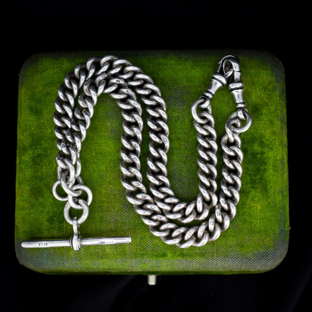 An antique sterling silver curb link Albert watch chain featuring a T-bar fastener and swivel clip.