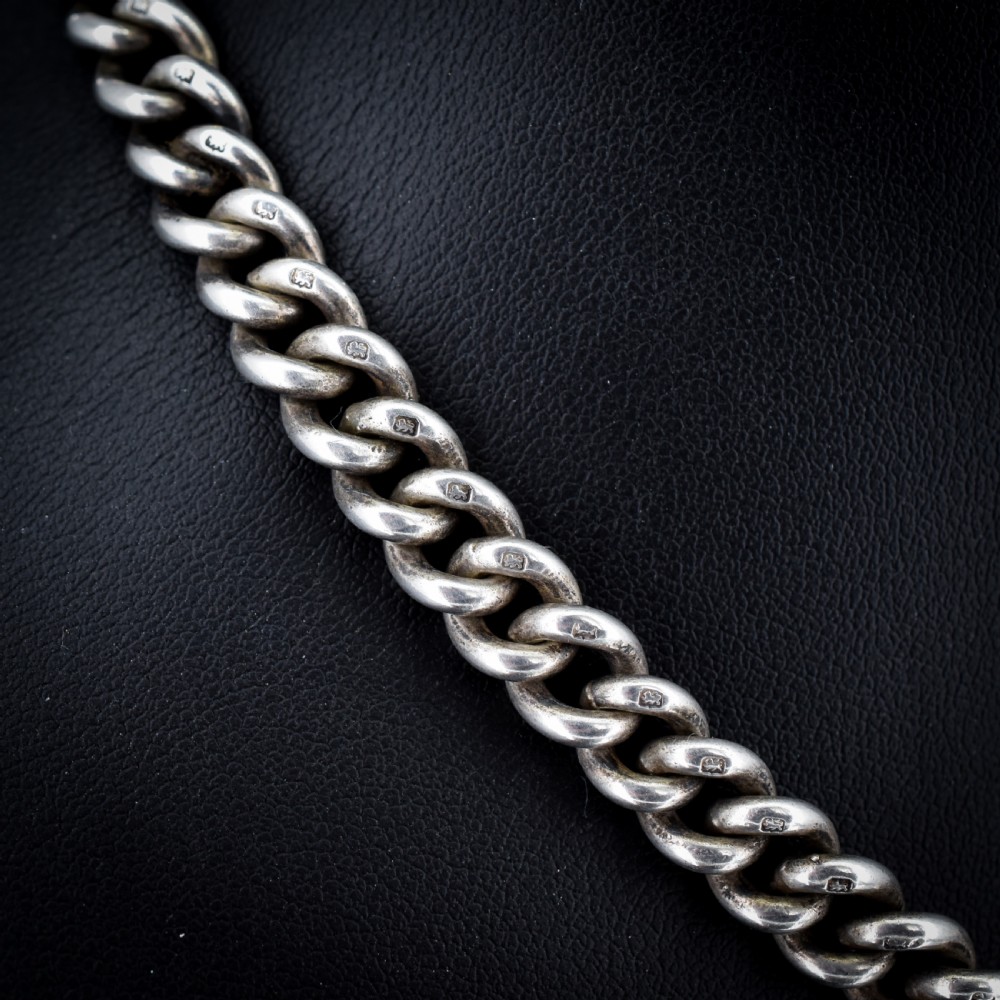 An antique sterling silver curb link Albert watch chain featuring a T-bar fastener and swivel clip. View V