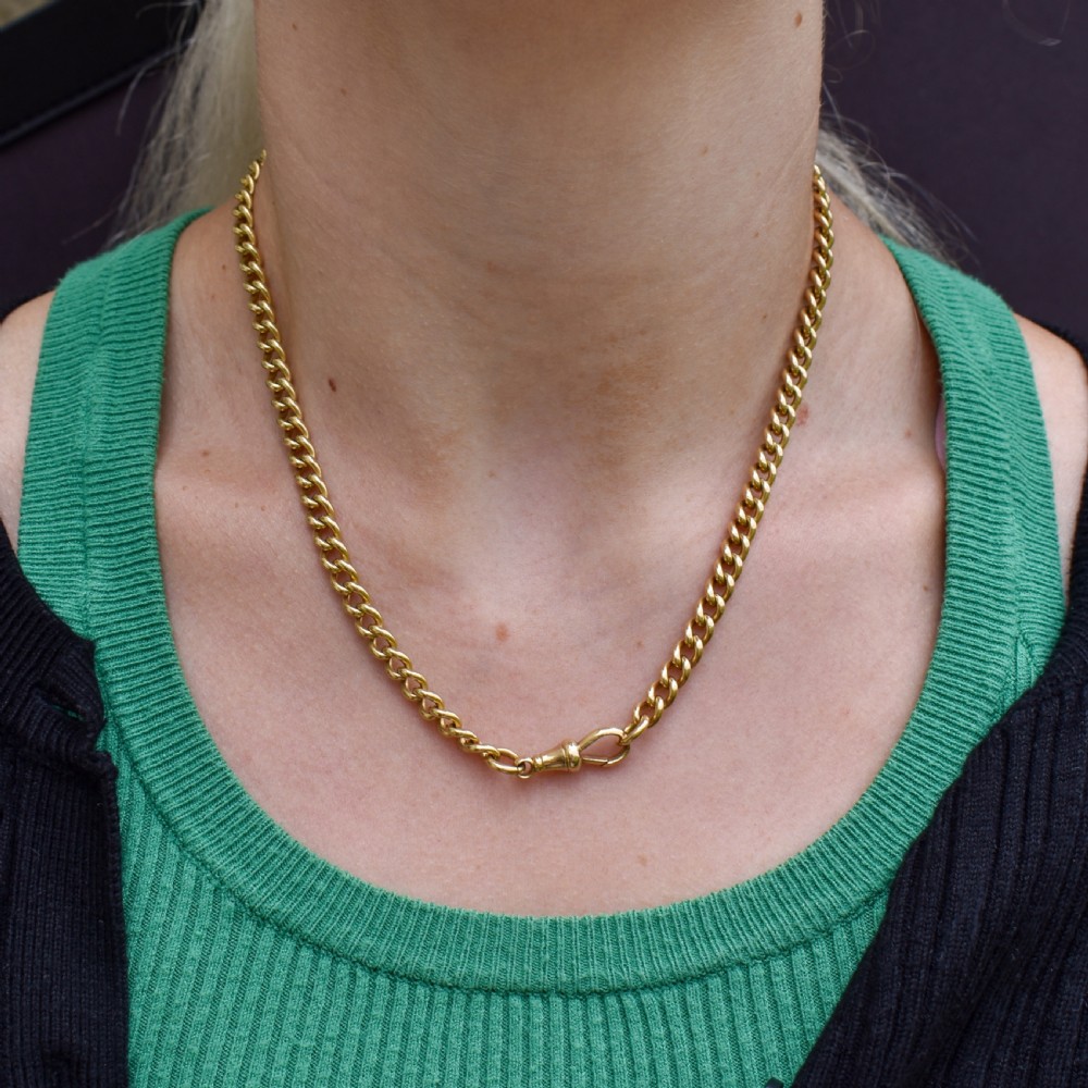 An 18ct yellow gold curb link chain necklace featuring a traditional dog clip fastener. View II