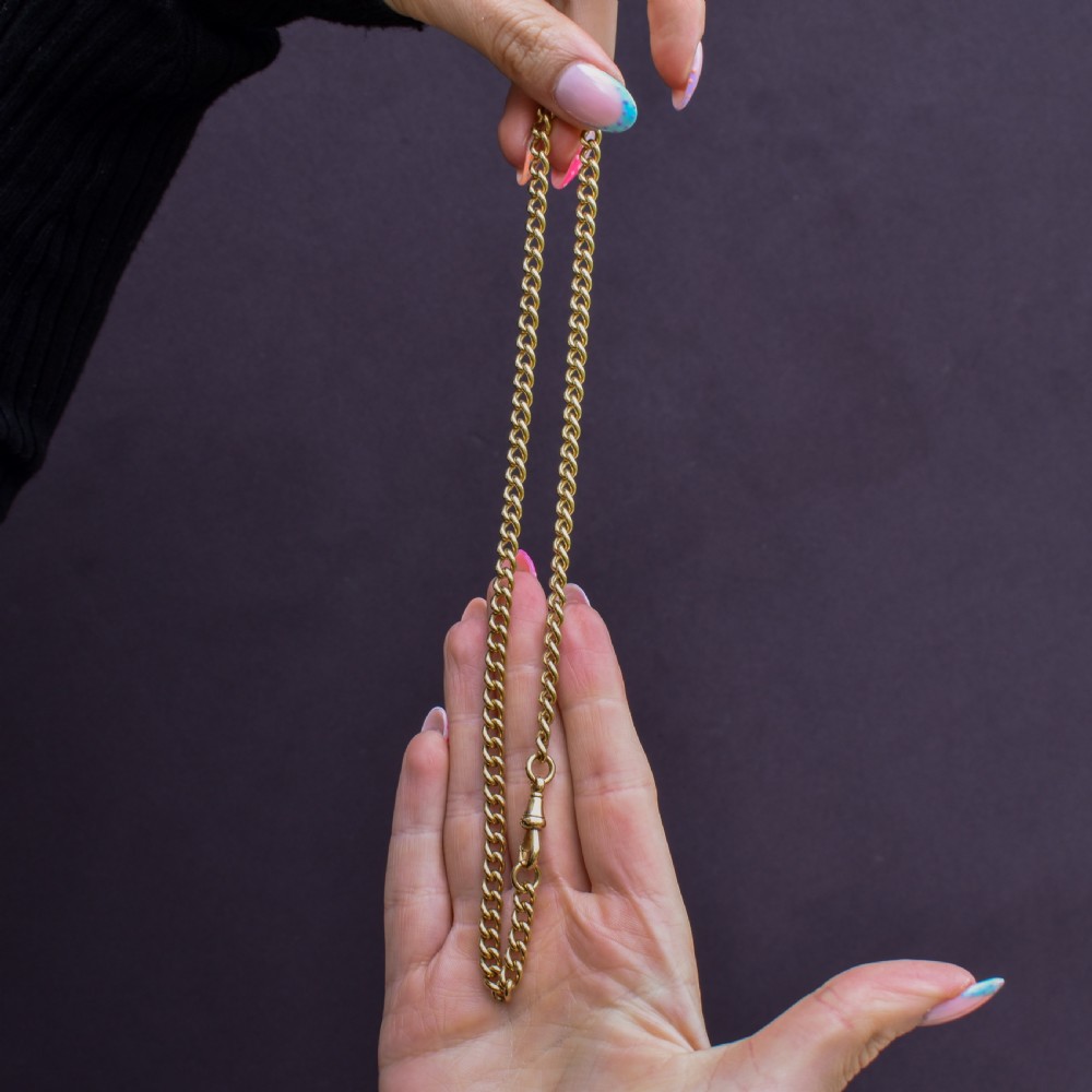 An 18ct yellow gold curb link chain necklace featuring a traditional dog clip fastener. View IV