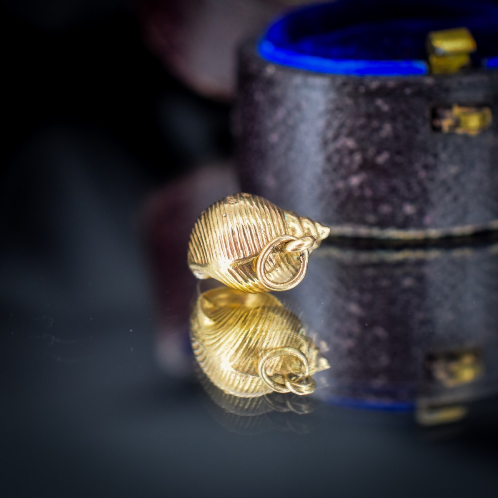 A small three-dimensional 9ct yellow gold seashell charm with ribbed texturing and a top suspension ring. View XI