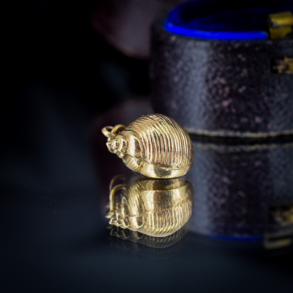 A small three-dimensional 9ct yellow gold seashell charm with ribbed texturing and a top suspension ring. View XII