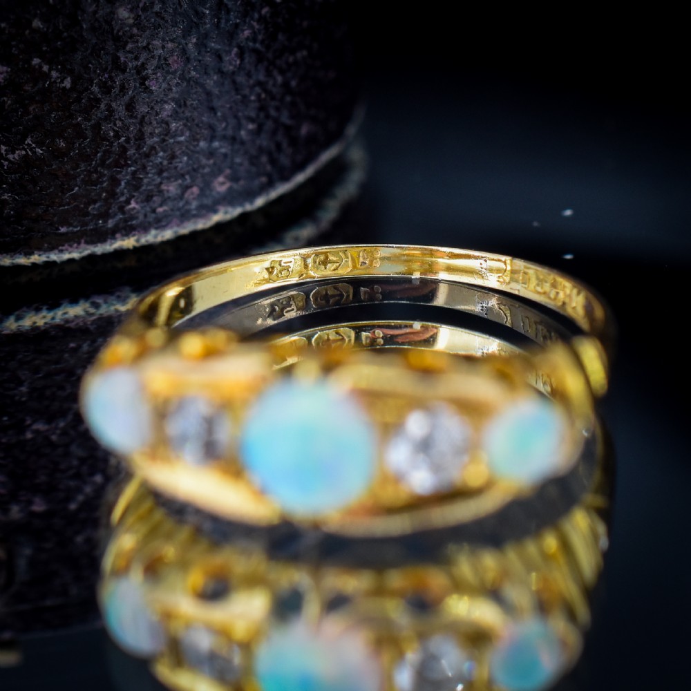 An Edwardian 18ct yellow gold boat ring set with three iridescent natural cabochon opals and two interspersed old-cut diamonds. View XI