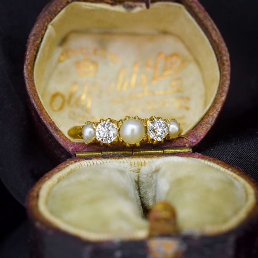 An 18ct yellow gold Victorian five-stone ring featuring three round pearls alternating with two old-cut diamonds.