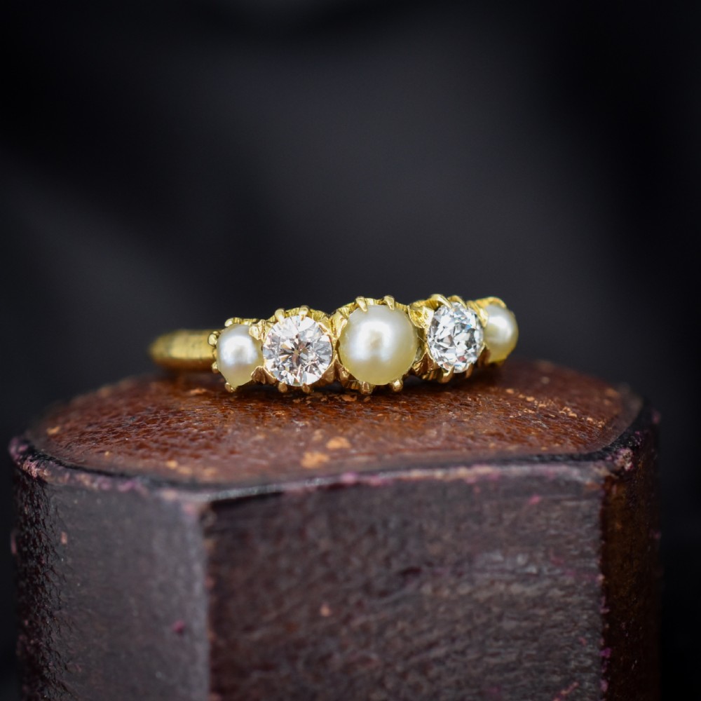 An 18ct yellow gold Victorian five-stone ring featuring three round pearls alternating with two old-cut diamonds. View IV