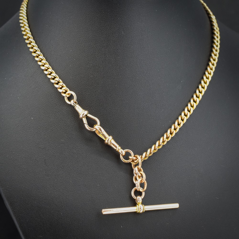 A 9ct yellow gold uniform curb link Albert watch chain featuring a T-bar and dog clip fastings. View IV