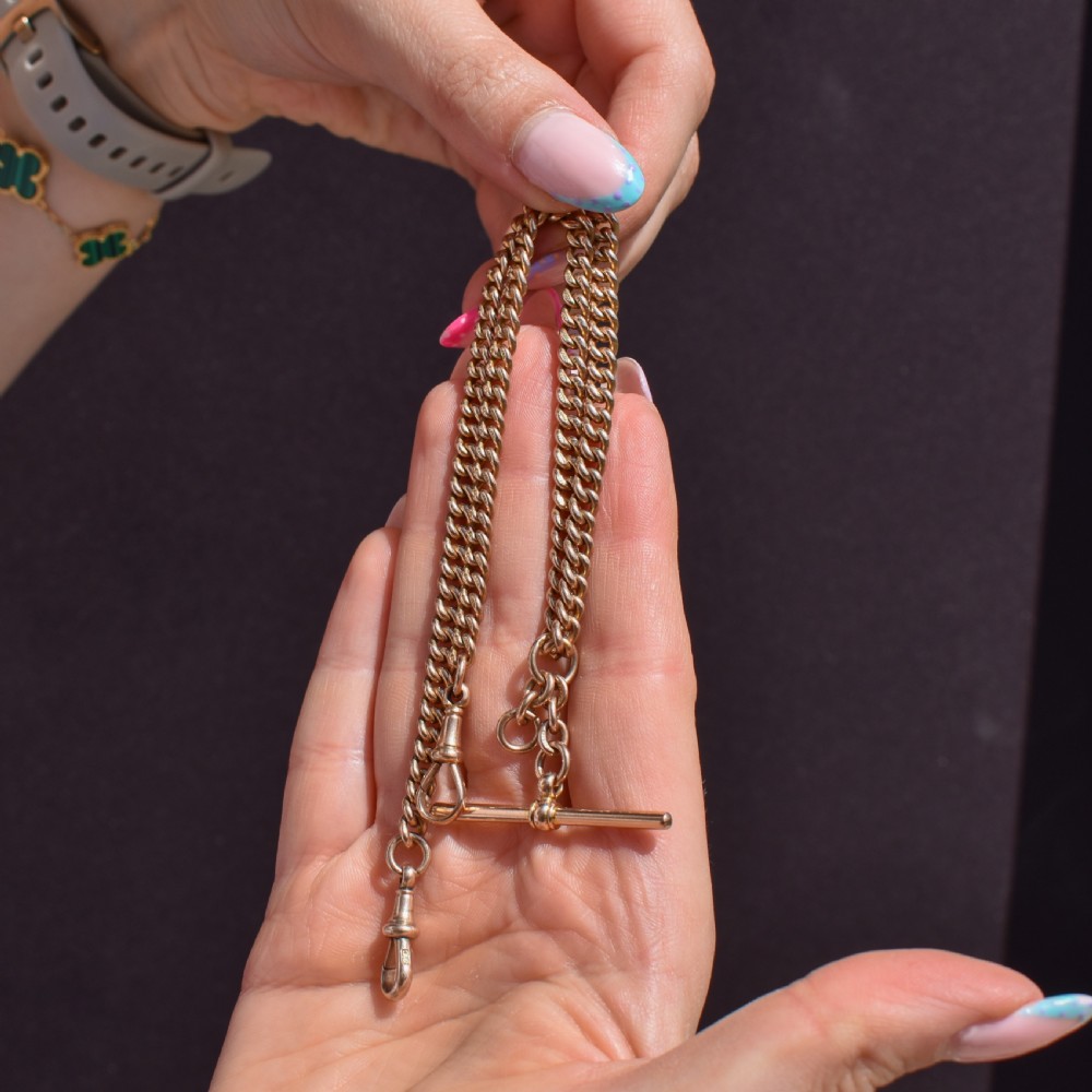 A 9ct yellow gold uniform curb link Albert watch chain featuring a T-bar and dog clip fastings. View VII