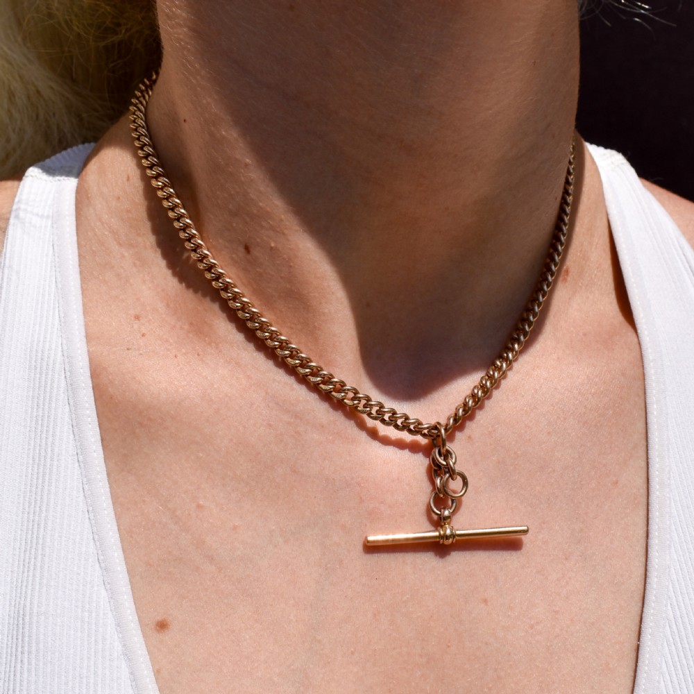 A 9ct yellow gold uniform curb link Albert watch chain featuring a T-bar and dog clip fastings. View VIII