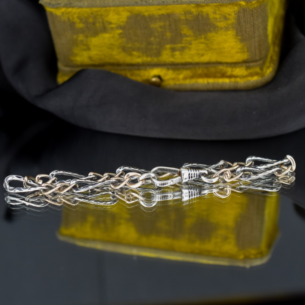 An antique chain bracelet consisting of patterned niello silver links connected by smooth gold links and secured with a swivel dog clip clasp. View III