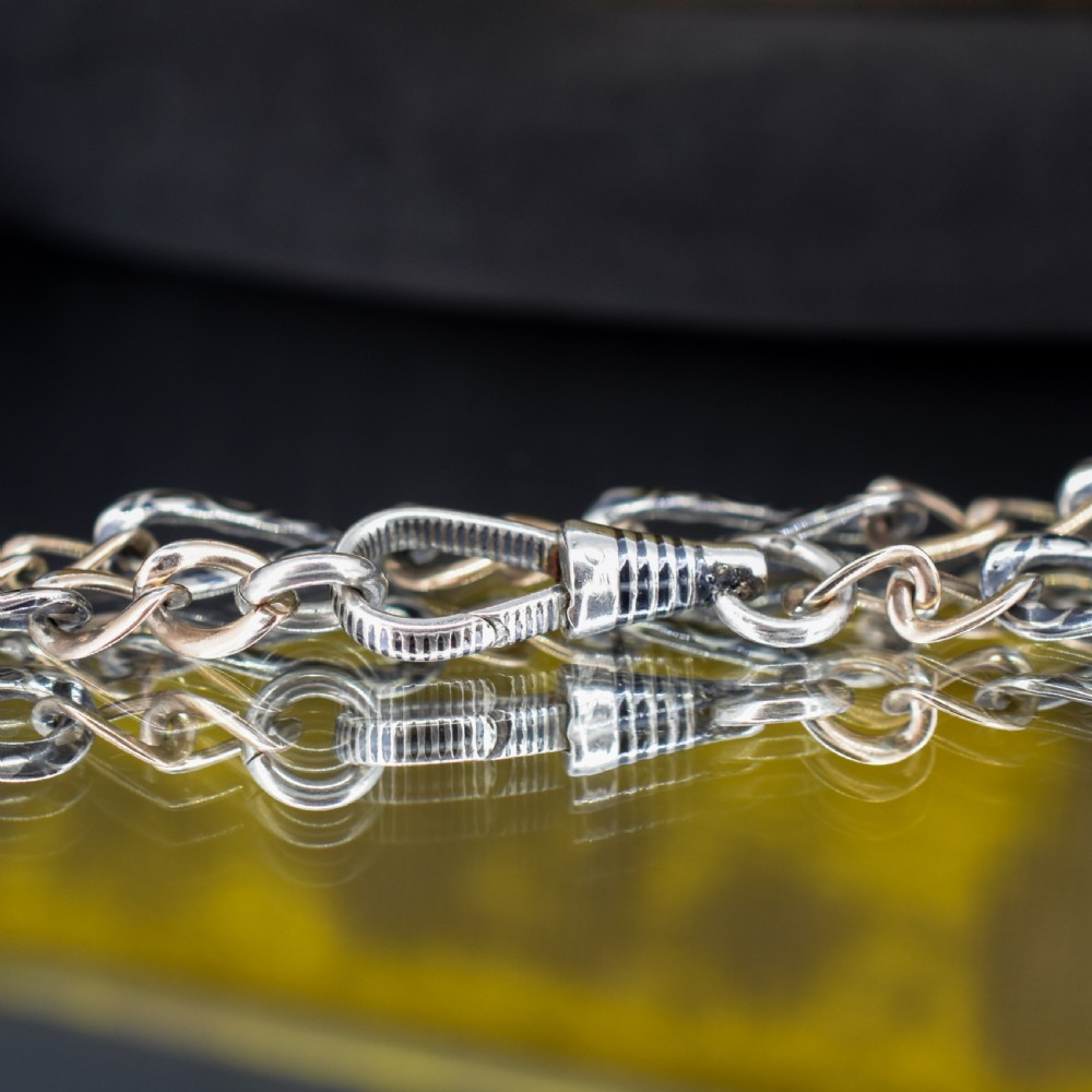 An antique chain bracelet consisting of patterned niello silver links connected by smooth gold links and secured with a swivel dog clip clasp. View IV