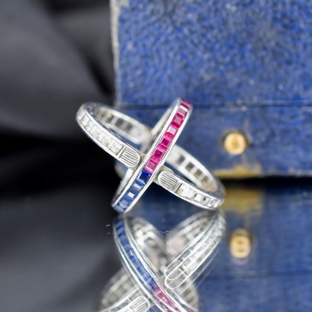 An Art Deco sterling silver swivel eternity ring featuring a central band of channel-set red paste stones flanked by hinged swivelling bands of clear paste stones. View IV