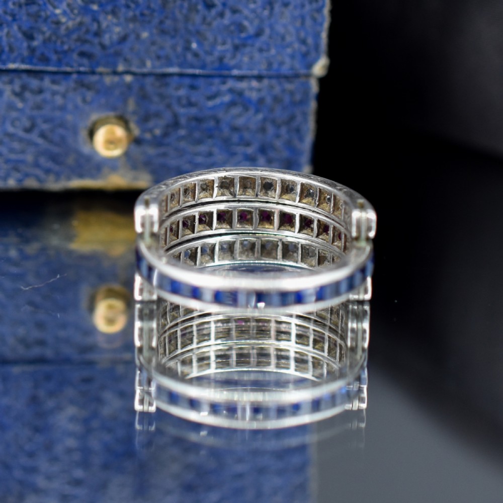 An Art Deco sterling silver swivel eternity ring featuring a central band of channel-set red paste stones flanked by hinged swivelling bands of clear paste stones. View VI