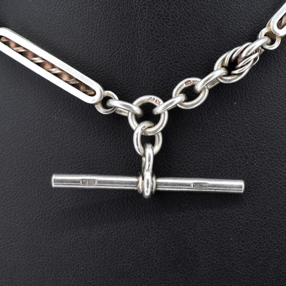 An antique sterling silver Albert chain necklace featuring elongated bar links, twisted rope sections, a T-bar attachment, and a swivel clasp. View III
