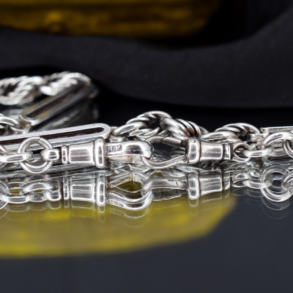 An antique sterling silver Albert chain necklace featuring elongated bar links, twisted rope sections, a T-bar attachment, and a swivel clasp. View VIII